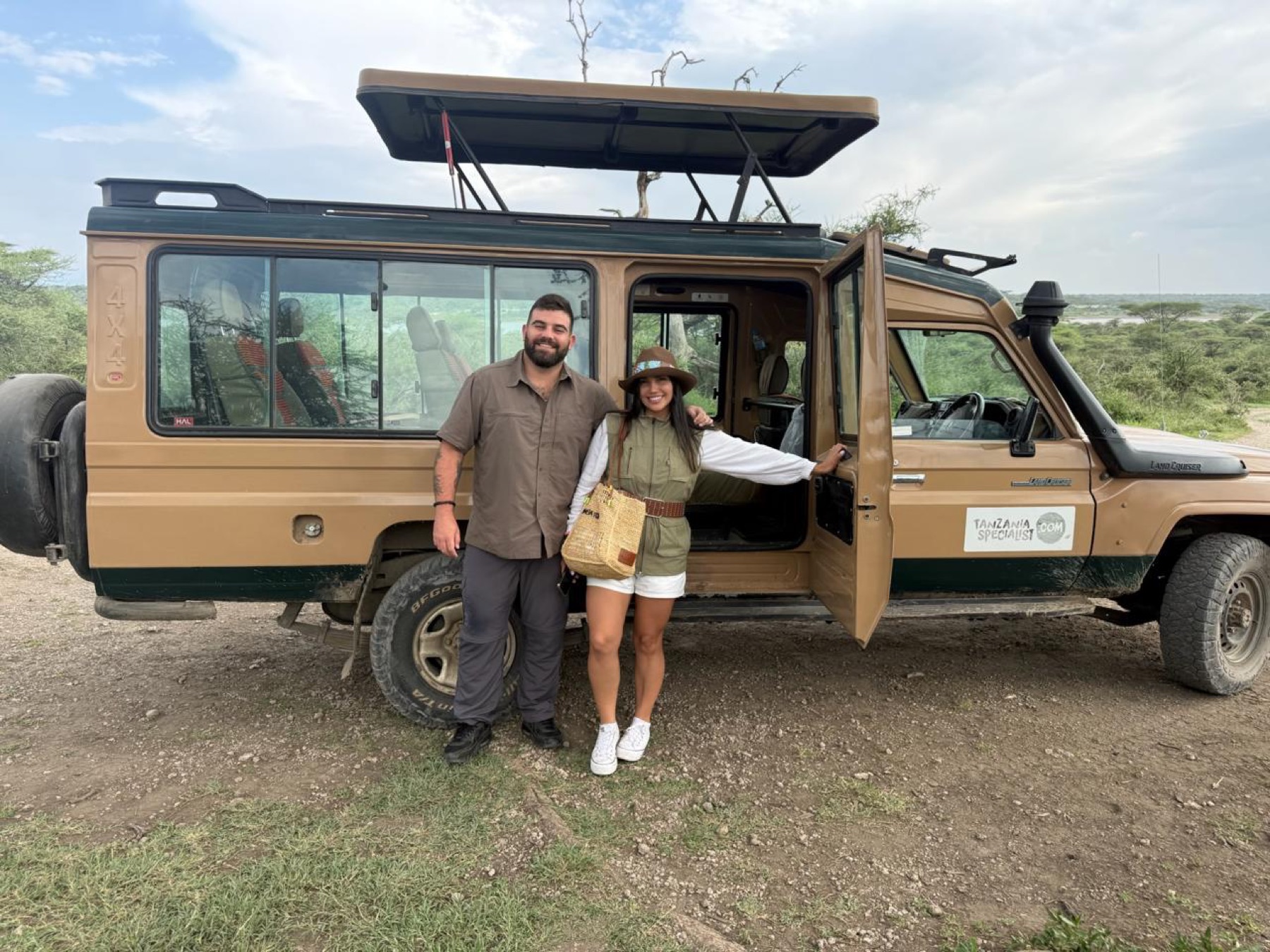 Constanza y Cristóbal junto a un jeep de safari en Tanzania